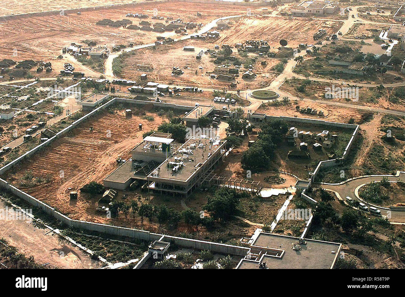 Vue aérienne de la partie gauche de l'ambassade américaine à Mogadiscio, en Somalie. Le quartier général de la Force opérationnelle interarmées pour restaurer l'espoir y est situé. Il est prévu de construire une ville de tentes sur le composé. Plusieurs tentes et d'équipement des Nations Unies sont situés à l'extérieur des murs de l'ambassade dans le haut du cadre. Cette mission est en appui direct à l'Opération Restore Hope. Banque D'Images