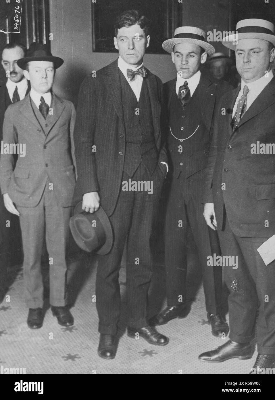 Jérémie A. O'Leary (avec chapeau) accusé de trahison aux États-Unis, peu de temps après son arrivée à New York, sur le chemin de l'immeuble fédéral. O'Leary a été capturé par des agents fédéraux sur une ferme d'élevage de poulets dans l'état de Washington où il a fui pour échapper aux procès. Banque D'Images