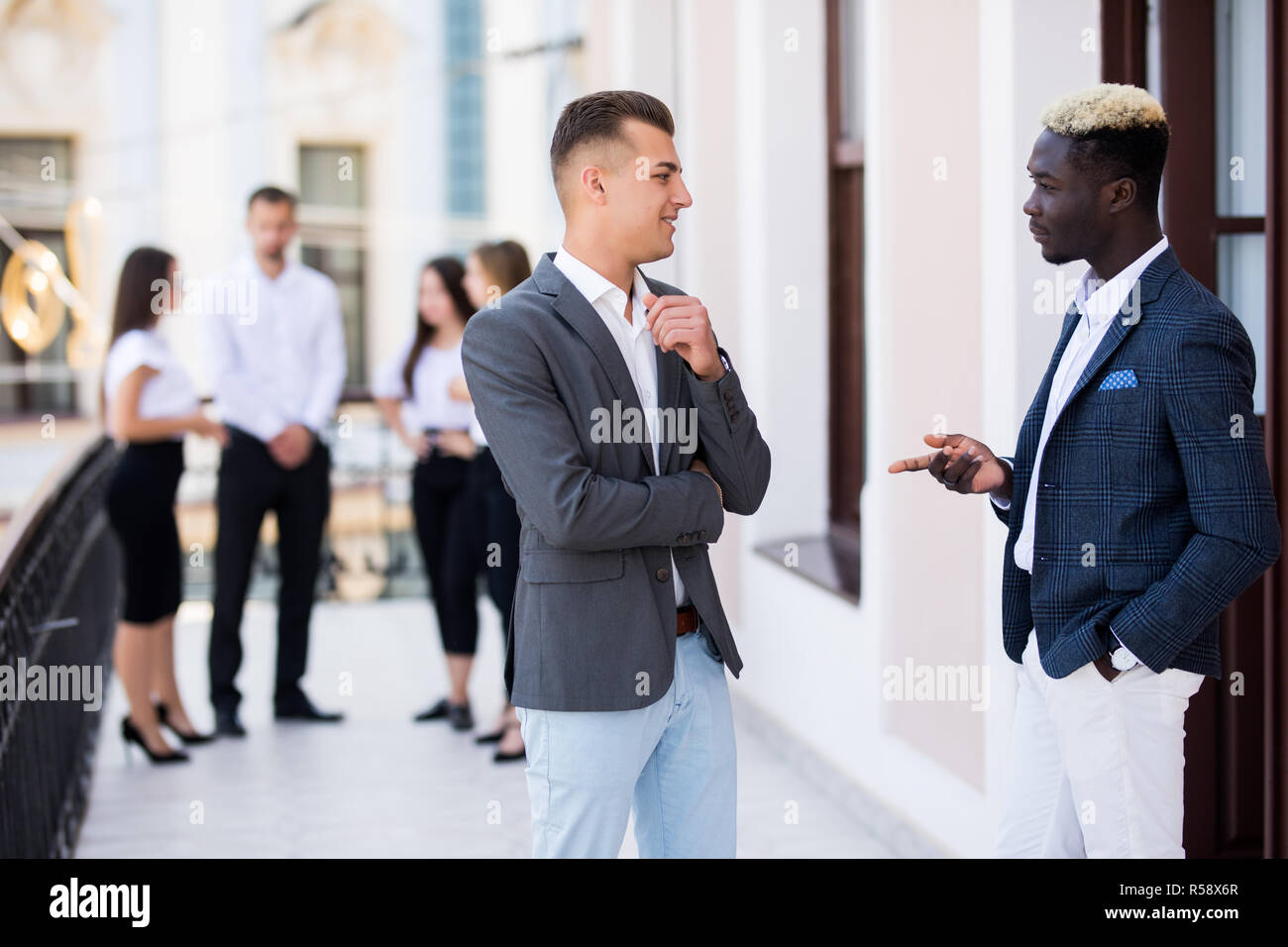 Deux jeunes collègues et de discuter devant leur équipe commerciale. Banque D'Images