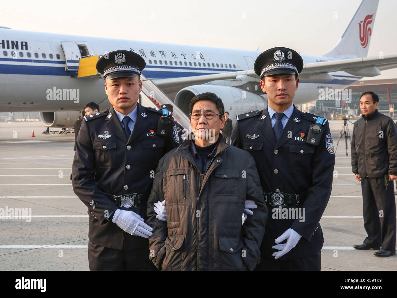 (181130) -- BEIJING, 30 novembre 2018 (Xinhua) -- Yao Jinqi est escorté par la police à l'Aéroport International de la Capitale à Beijing, capitale de Chine, le 30 novembre 2018. Yao Jinqi, un devoir et suspect du crime ancien chef adjoint de Xinchang County dans l'est de la Chine, la Province de Zhejiang, a été extradé vendredi vers la Chine à partir de la Bulgarie. Yao, qui ont fui à l'étranger en décembre 2005, est devenu le premier ancien fonctionnaire Chine extradé d'un État membre de l'UE. Coordonné par un bureau chargé de la récupération des ressources et de rapatriement fugitives centrale de Chine dans le cadre de la lutte contre la corruption, le groupe de coordination On a aussi la firs Banque D'Images
