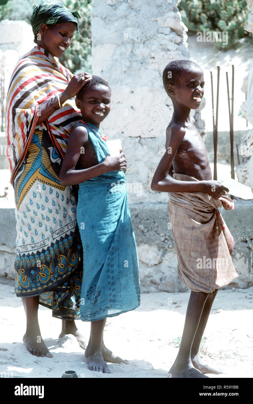 1993 - une famille somalienne est en ligne tout en attendant d'être examiné par un corpsman marine. Détachement de soutien logistique du combat 15 (CSSD-15) mène un programme d'action civique médicale dans les rues de la ville au cours de l'effort de secours multinationales l'Opération Restore Hope. Banque D'Images