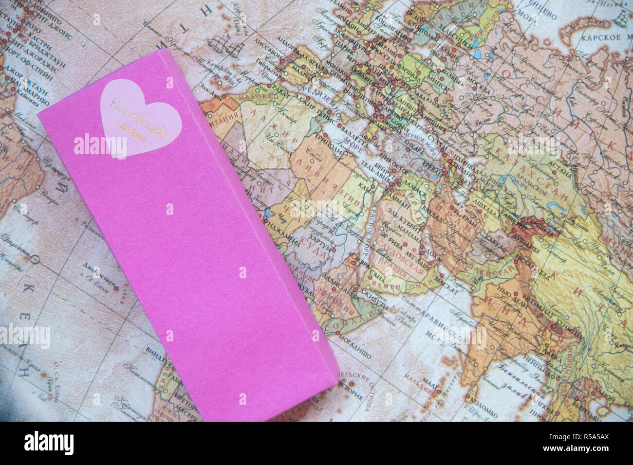 Grande boîte cadeau rose avec un cœur d'amour sur la carte du monde avec des inscriptions en langue russe Banque D'Images