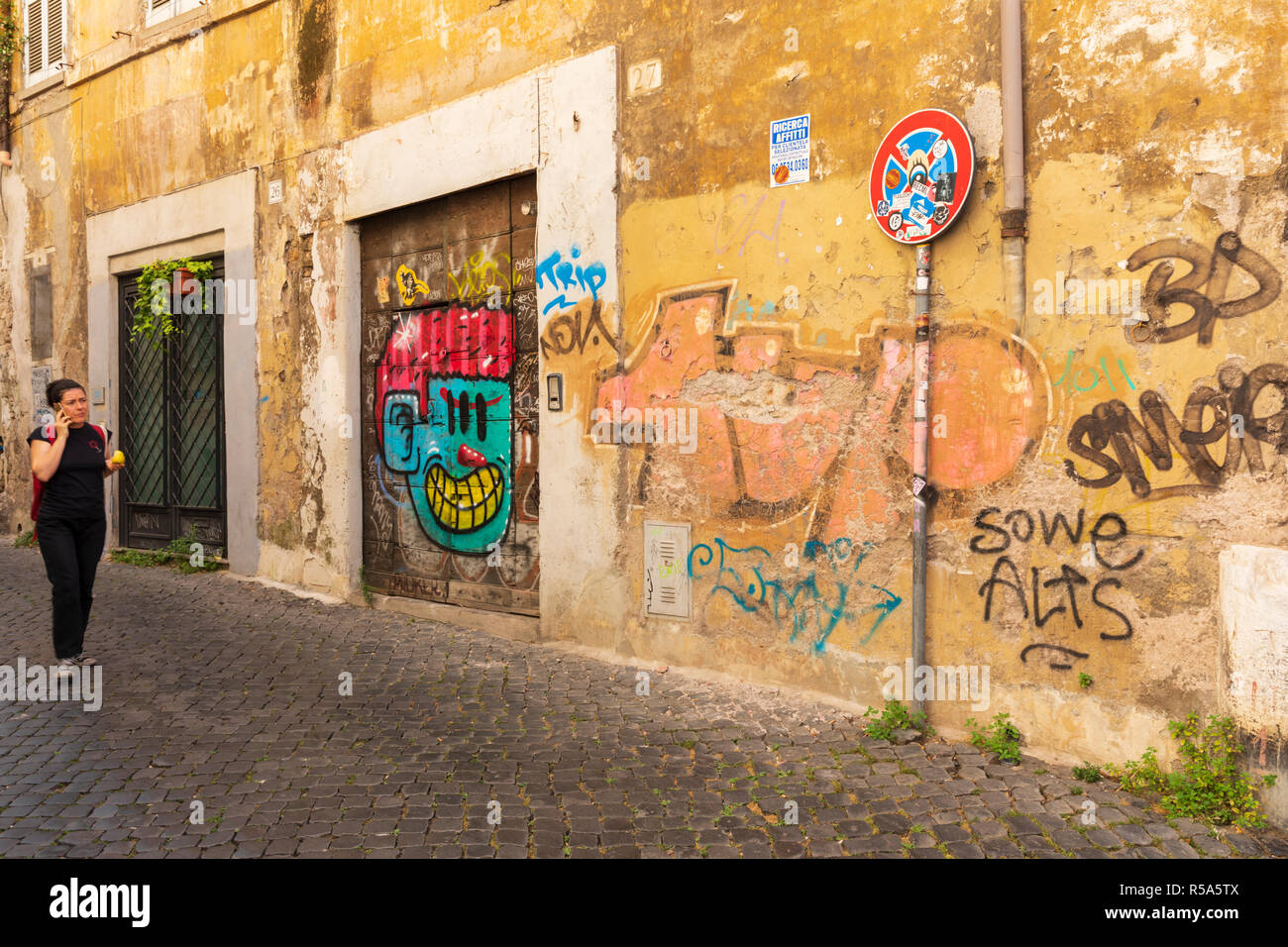 Graffitis colorés ornent un mur de backstreet dans le Trastevere, Rome, Italie. Banque D'Images