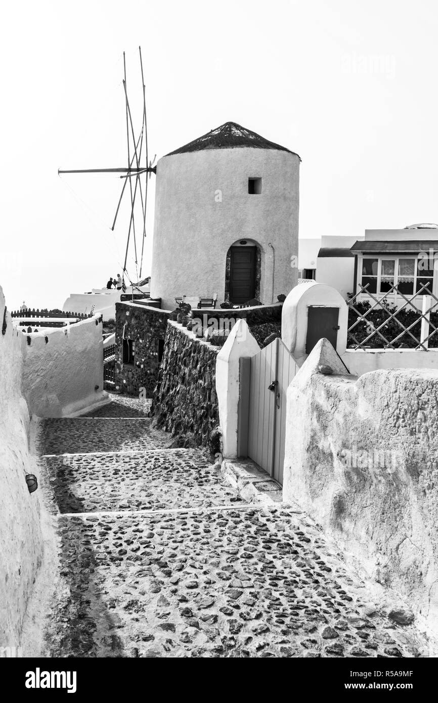 Une rue pavée menant à un moulin à vent dans le village d''Oia, à Santorin, en Grèce. Banque D'Images