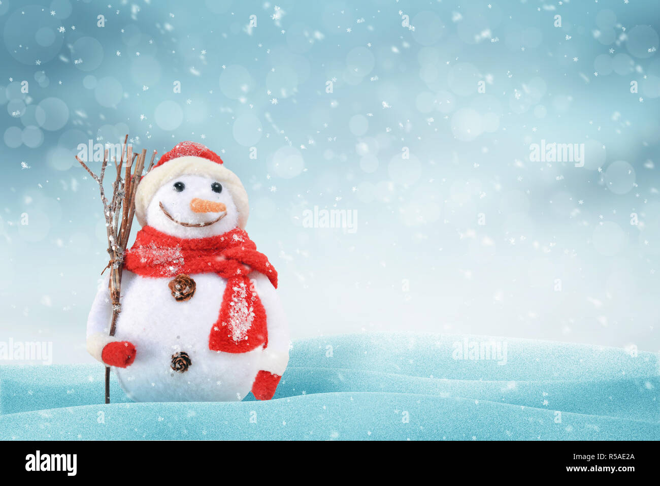 Scène de Noël avec un mignon bonhomme de neige. Espace libre pour le texte sur le côté droit, de la lumière et snob. bokeh en arrière-plan. Banque D'Images