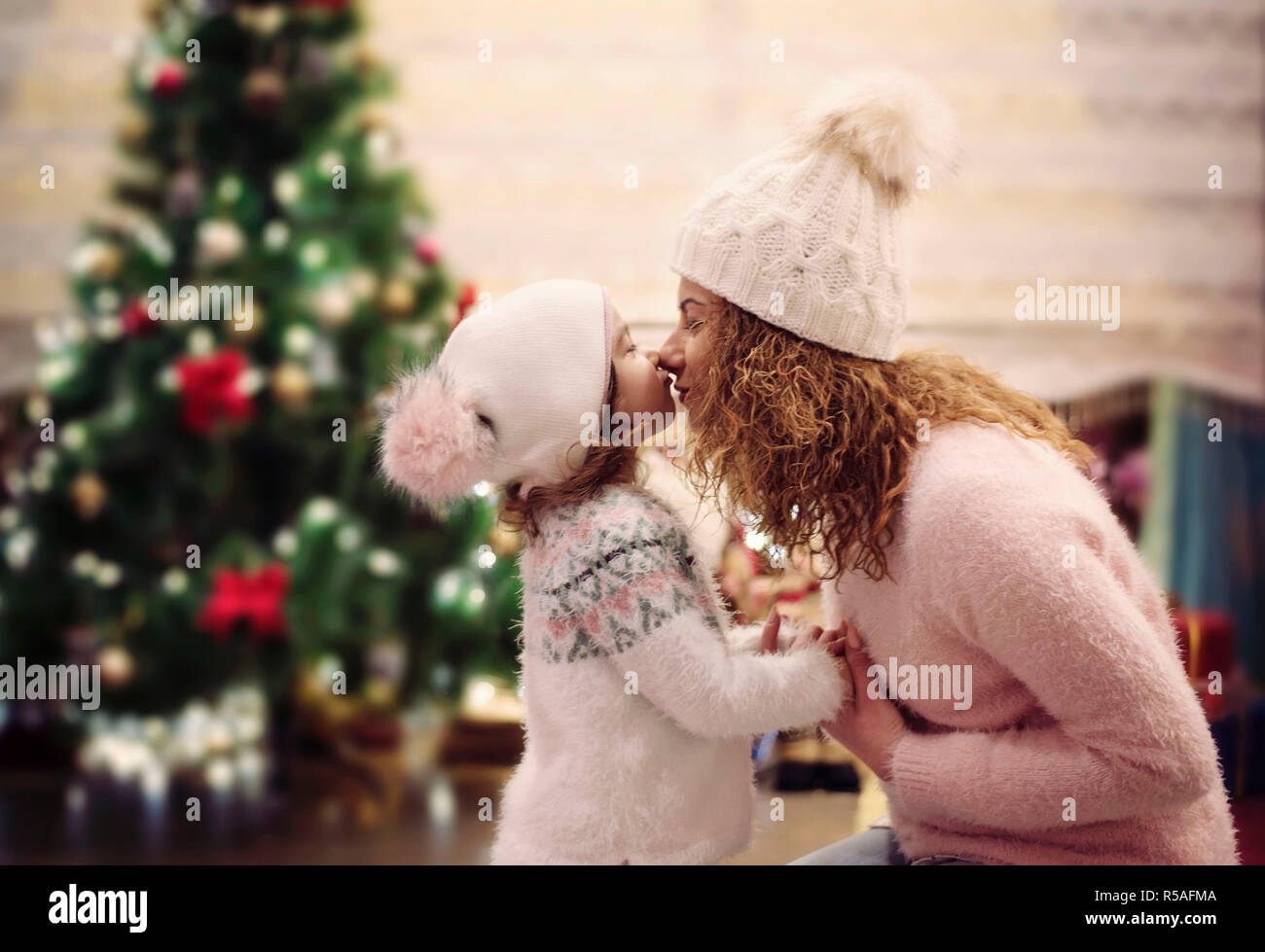 Joyeux Noël et bonnes fêtes de concept. Cheerful maman et son joli fille s'amusant en salon à la décoration confortable près de l'arbre de Noël. Mothe Banque D'Images