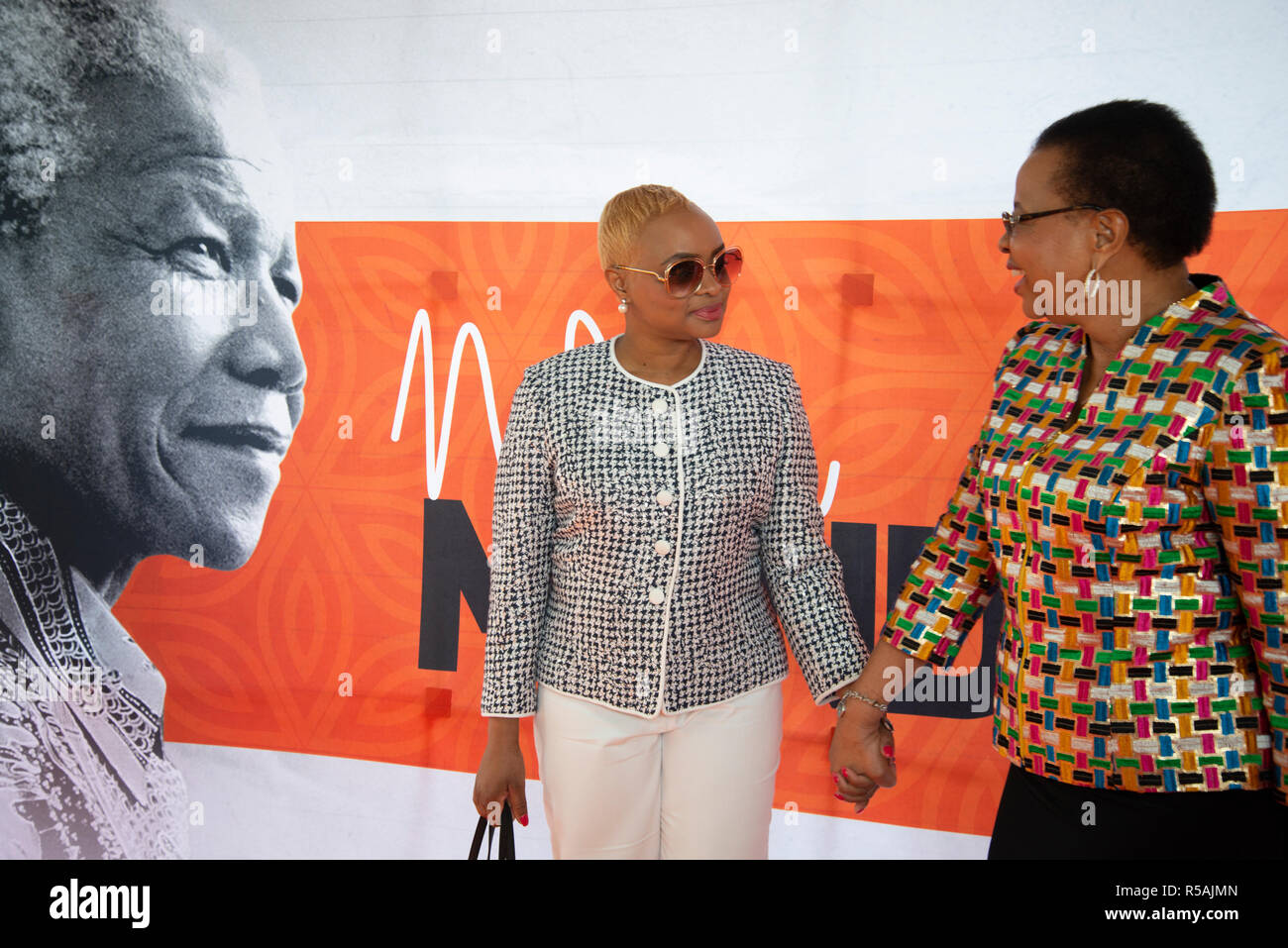 Soweto, Afrique du Sud, le 29 novembre, 2018. Graça Machel et sa fille Josina devant la bannière avec la photo de Nelson Mandela, à l'extérieur Imbizo Hall, à Soweto. Le Machels est arrivé d'assister à Is'thunzi (Sabafazi la dignité de la femme), un événement organisé à l'honneur ils l'héritage de Mandela, de même que célébré au cours de son 100e anniversaire. Oprah Winfrey était le conférencier de l'événement. Credit : Eva-Lotta Jansson/Alamy Live News Banque D'Images