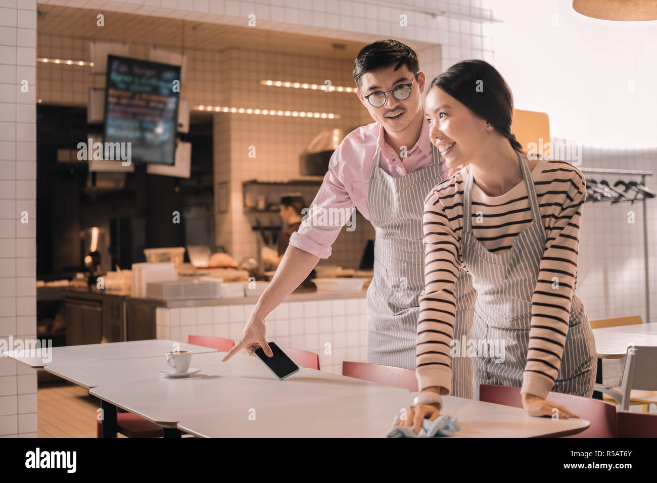 Jeune couple travaillant à temps partiel comme serveurs dans le restaurant Banque D'Images