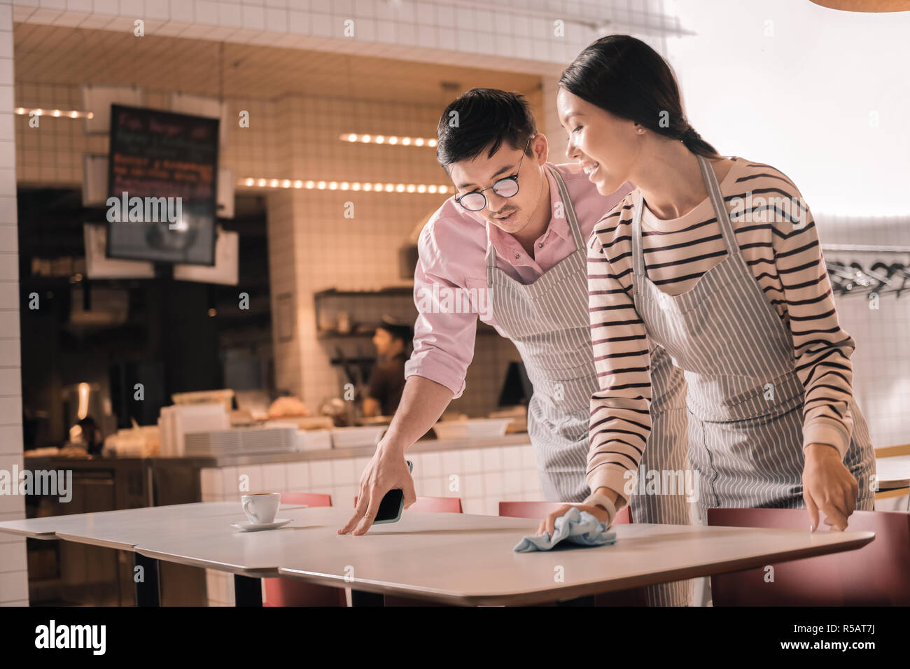 Manager portant des lunettes en donnant des instructions pour serveuse Banque D'Images