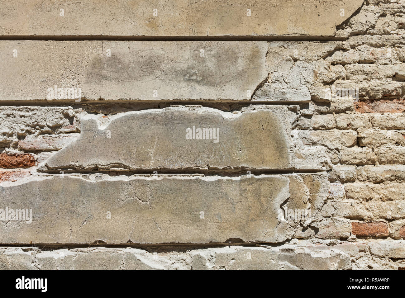 Vue détaillée d'un vieux mur de briques avec broken surface de plâtre. Banque D'Images