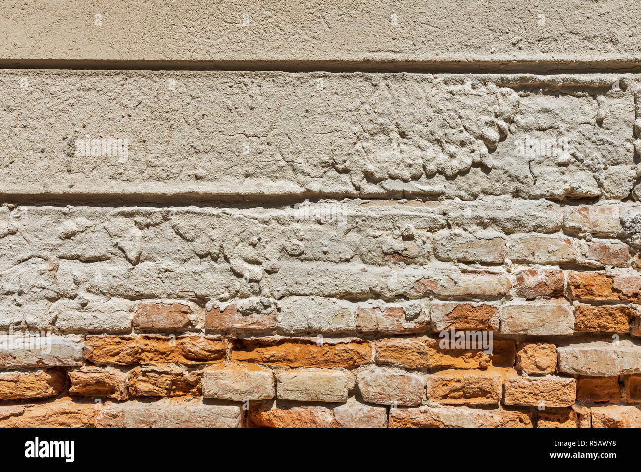 Vue détaillée d'un vieux mur de briques avec broken surface de plâtre. Banque D'Images