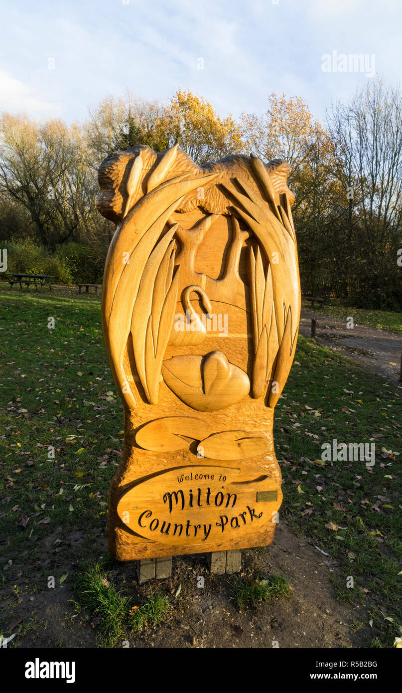 Milton Country Park signe de bienvenue en bois sculpté en coucher de soleil côté allumé Banque D'Images
