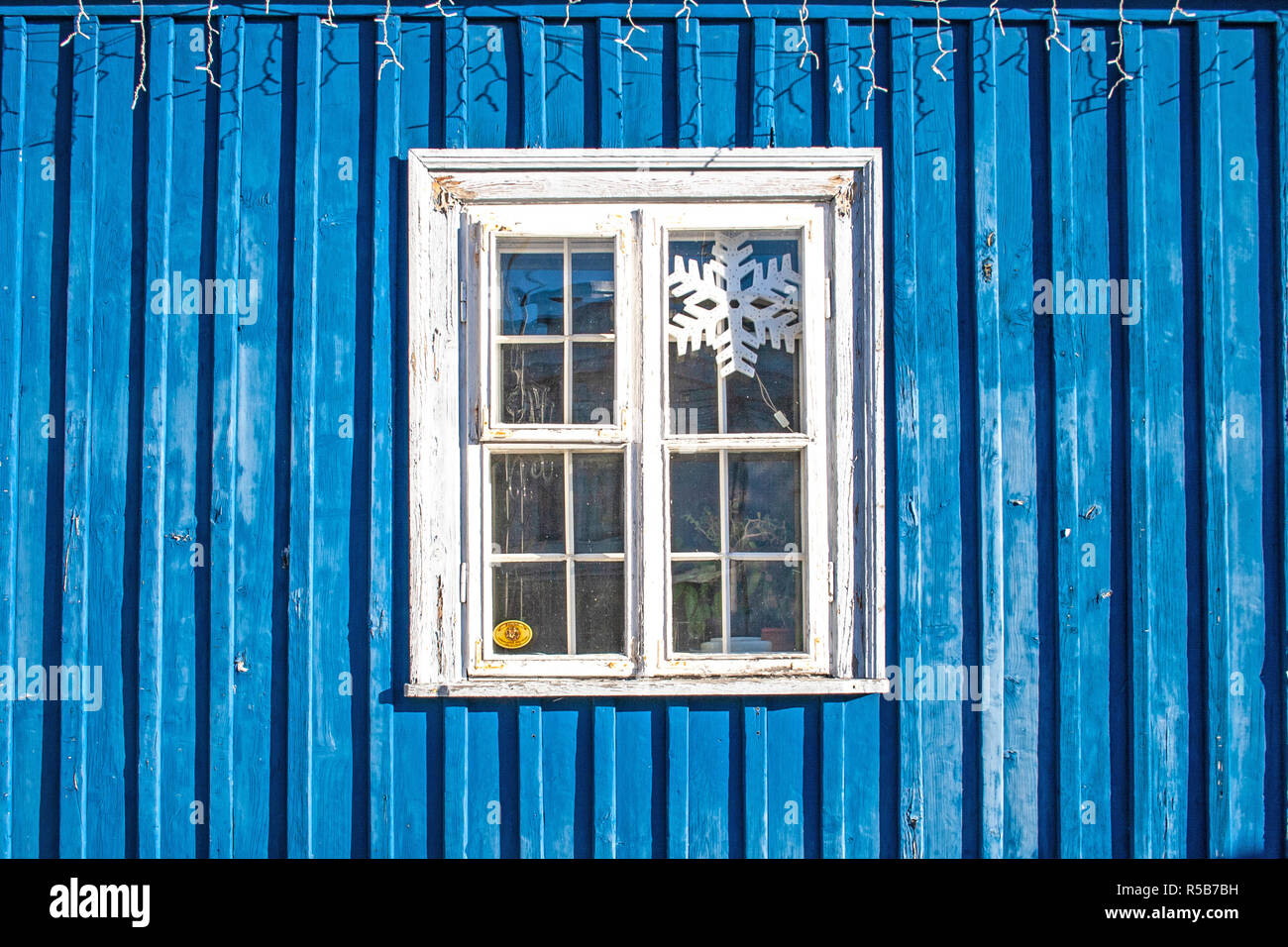 Vieille fenêtre en bois blanc mur en bois bleu, les lumières de Noël et snowflake Banque D'Images