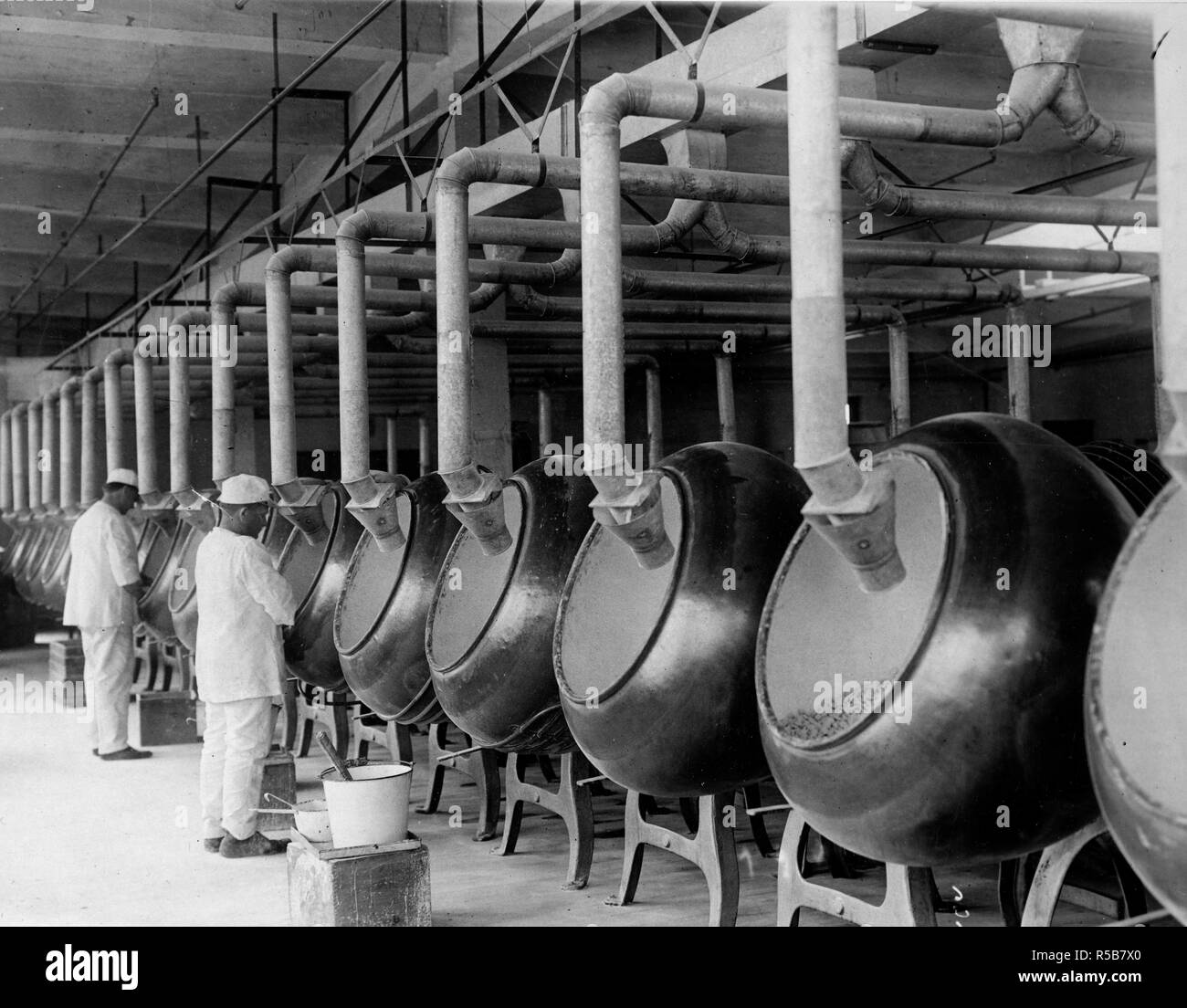 Prendre les comprimés à mâcher chiclets, comme est plus intéressant après pratiquement le même processus que placé dans une grande cuve qui sont continuellement fonds renouvelable. Le sucre à la menthe poivrée est versé dans les cuves et ballottée chiclets intérieur, sur la quantité de revêtement uniforme de sucre. Les grandes cuves dans lesquelles le sont placés pour l'chiclets procédé de revêtement est illustré. Banque D'Images