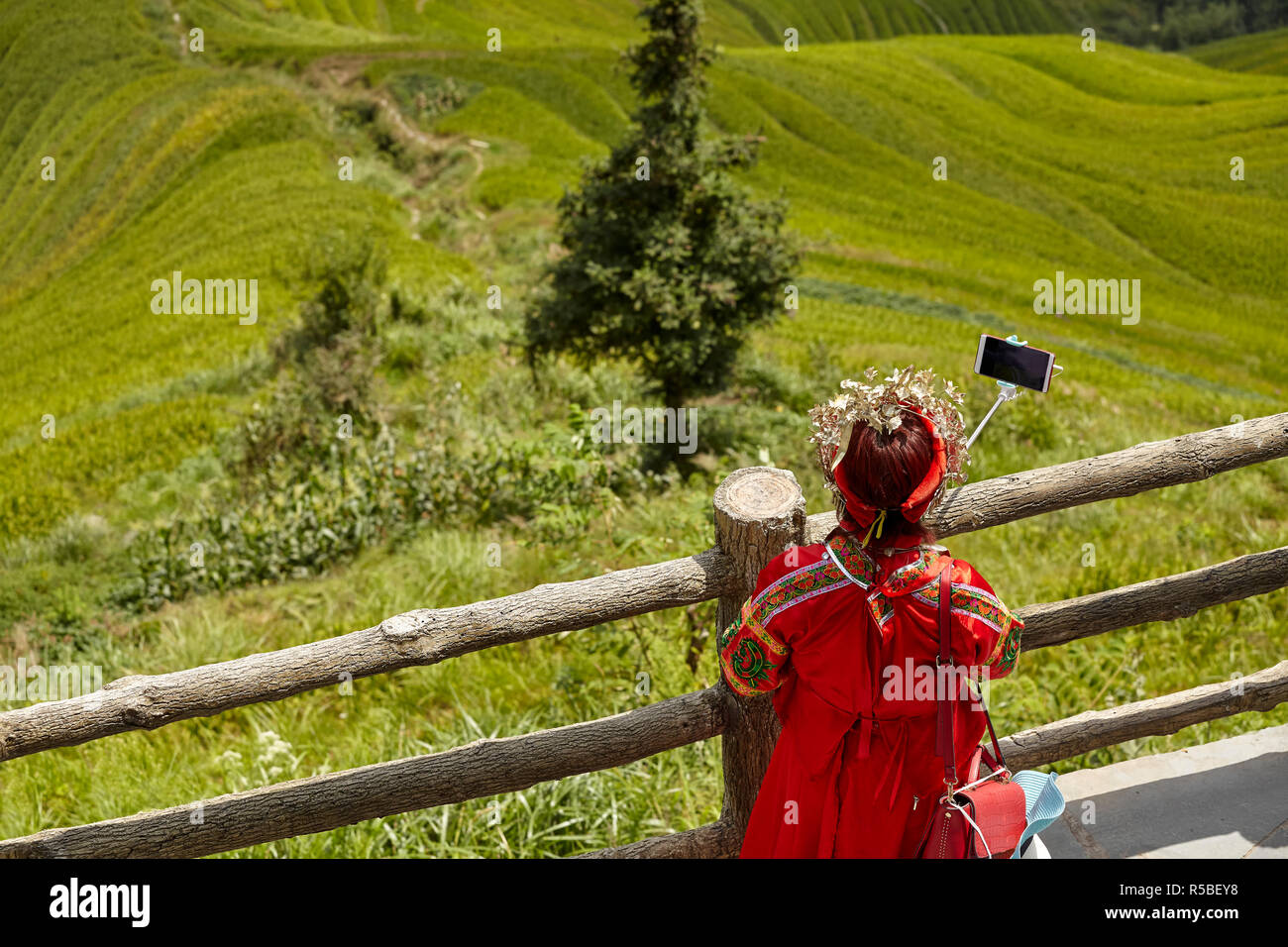 Une femme non identifiée en costume traditionnel prend au riz selfies Longji terrasses, l'une des principales attractions touristiques de Guilin, Chine. Banque D'Images