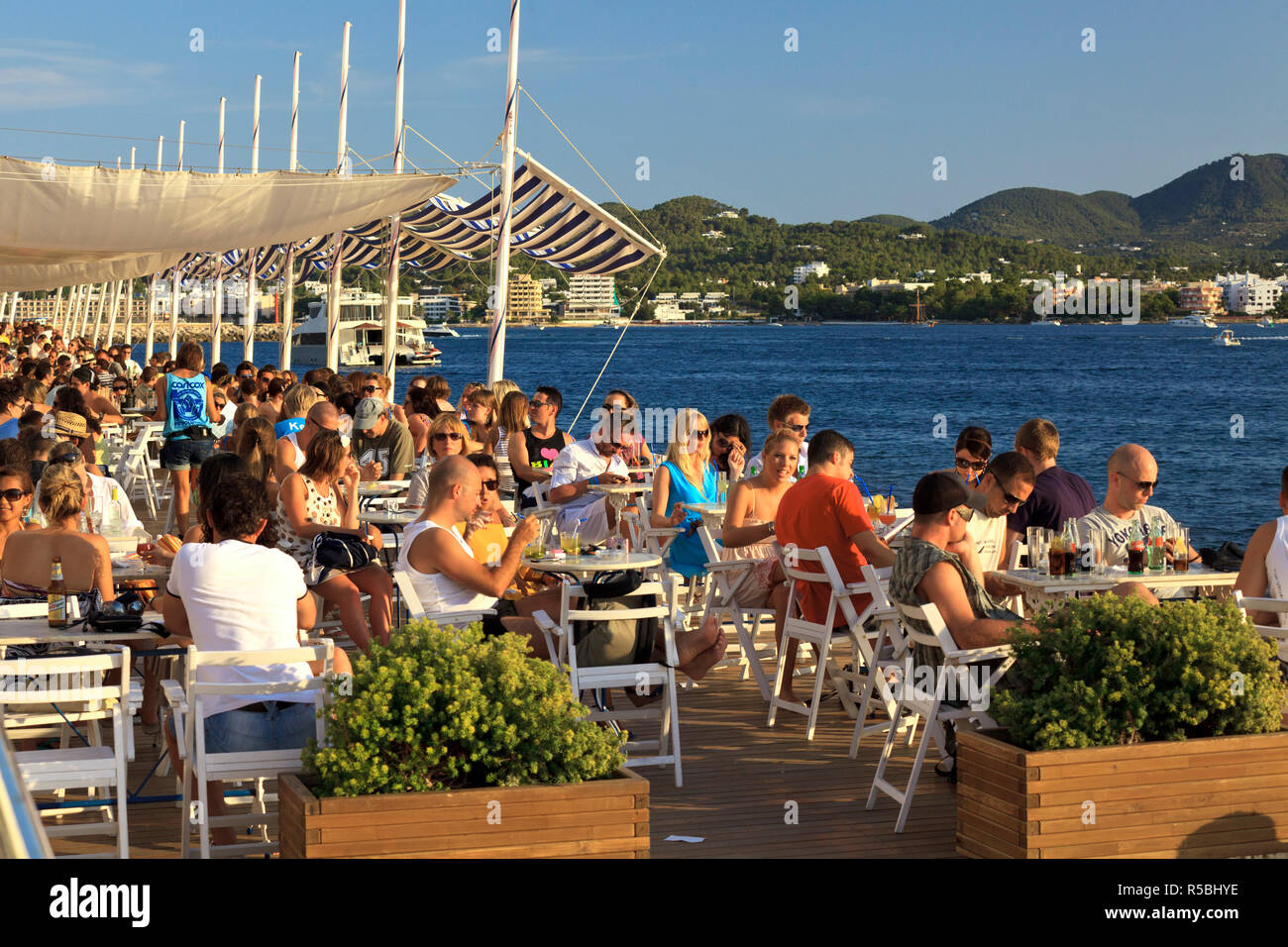 L'Espagne, Îles Baléares, Ibiza, Sant Antoni, les gens regardant le coucher du soleil sur le célèbre Café del Mar Banque D'Images