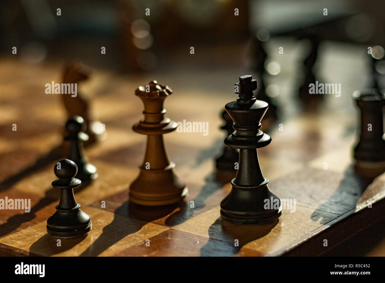 Reine et Roi : pièces d'échecs sur un conseil. La Reine blanche mates le roi noir dans un jeu d'échecs. Banque D'Images