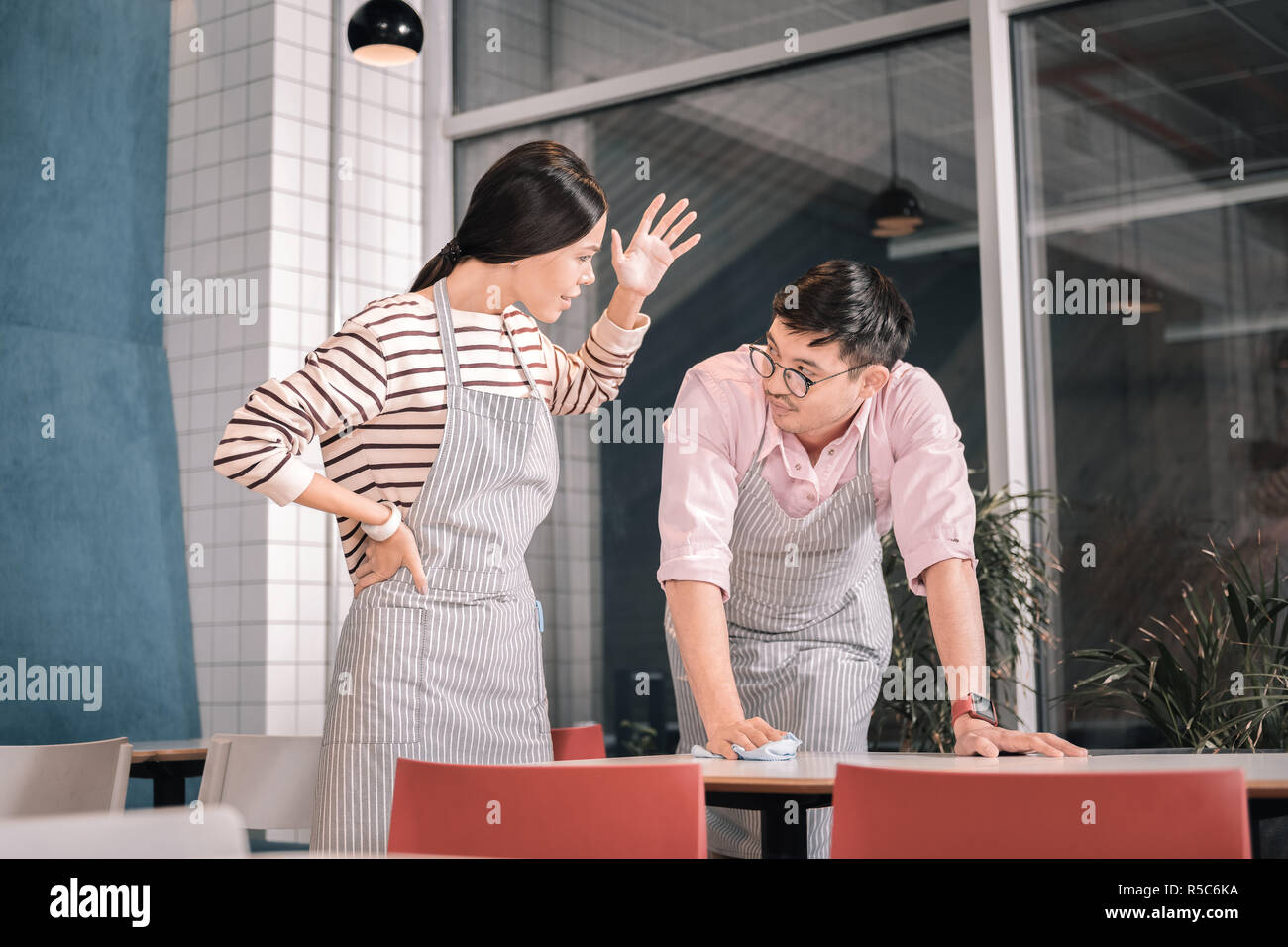 Dark-haired serveuse émotionnelle faisant valoir à son collègue Banque D'Images