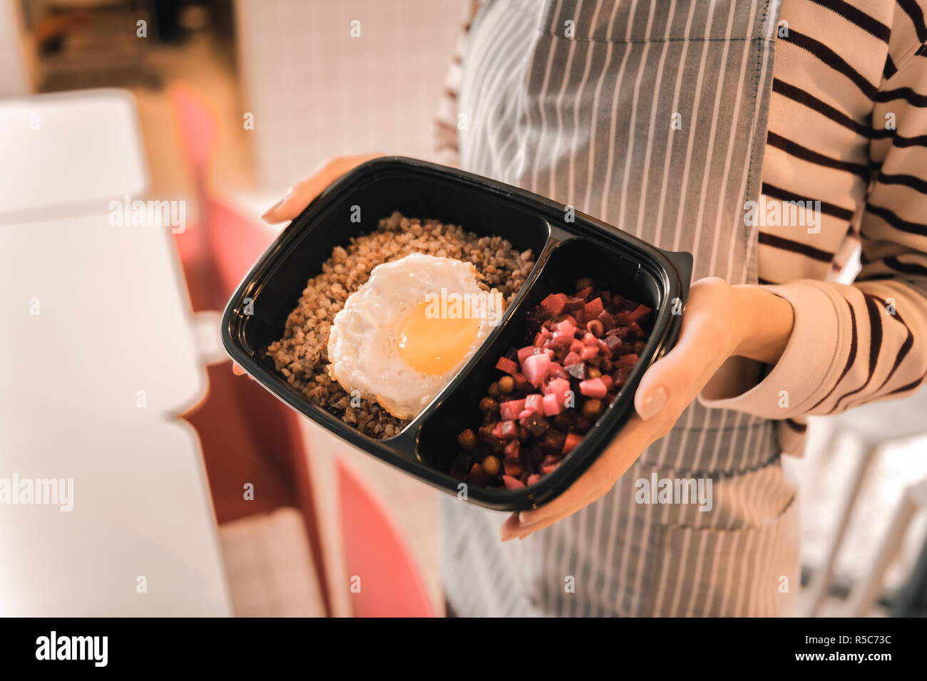 Waitress holding fort avec quelques oeufs avec du sarrasin et salade de betteraves rouges Banque D'Images