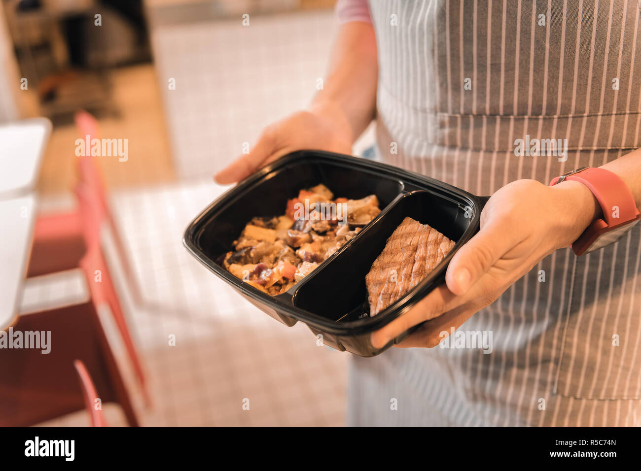 Waiter holding boîte à lunch avec ragoût de légumes et de la viande de boeuf Banque D'Images