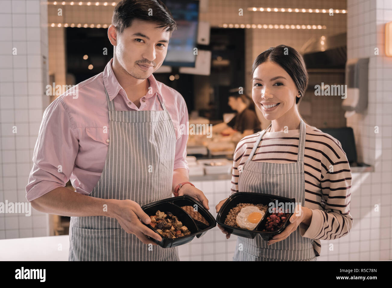 Deux serveurs transmission agréable nice holding boîtes à lunch avec des aliments savoureux Banque D'Images