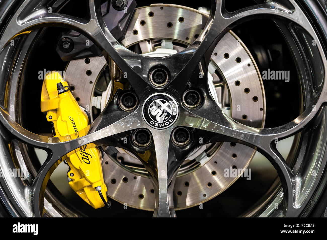 Bucarest, Roumanie - 19 octobre 2018 : Alfa Romeo Logo Sign vue rapprochée sur roues en alliage voiture jaune avec des étriers de frein et frein à disque percé Banque D'Images