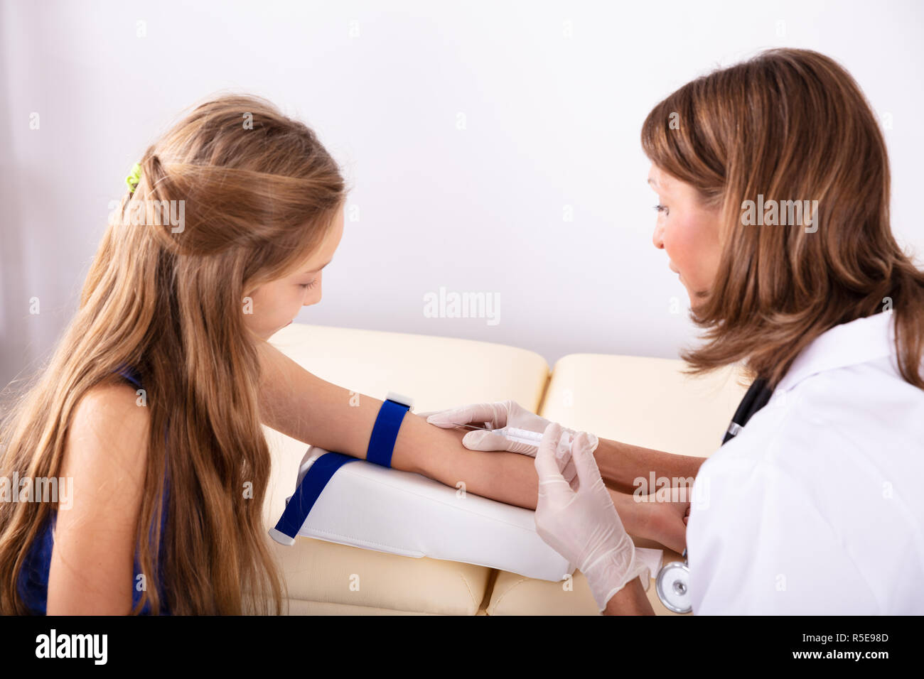 Close-up of a young female Doctor Injecting Patient avec seringue pour recueillir des échantillons de sang Banque D'Images