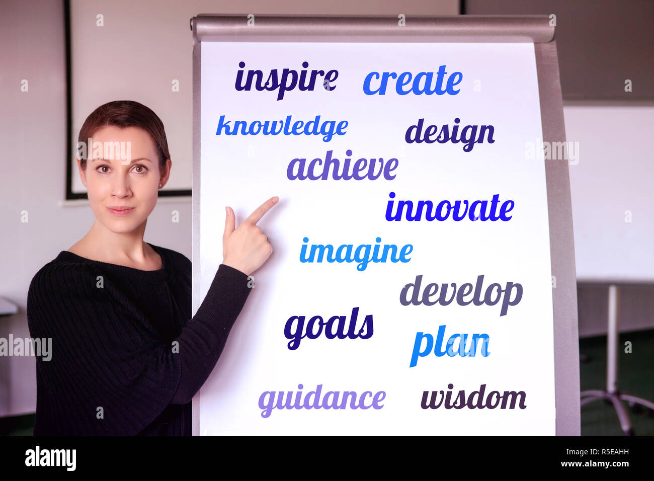 Jeune brunette woman standing at flipchart avec orientée d'mots sur elle Banque D'Images