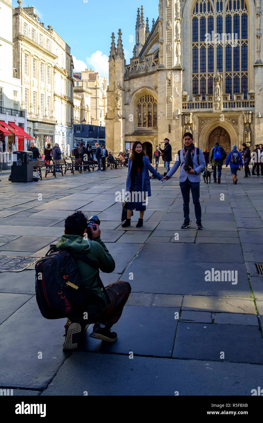 Les visiteurs d'avoir leur photo prise en face de l'abbaye de Bath. Un jour en hiver le centre-ville de Bath, Somerset england UK Banque D'Images