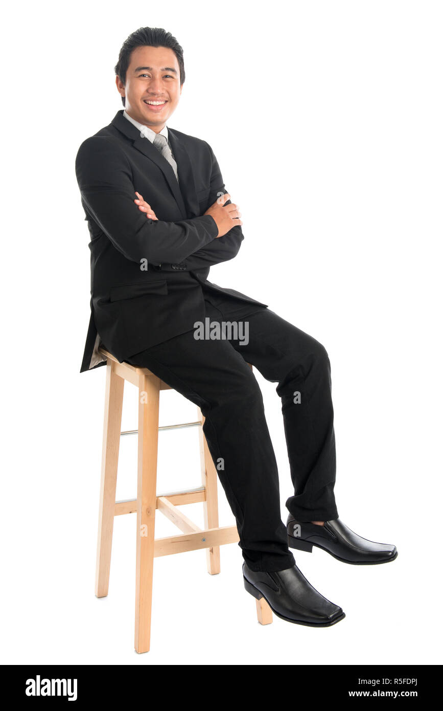 Corps complet Asian businessman sitting on chair croisé arm Banque D'Images