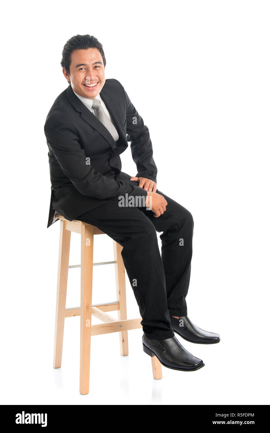 Corps complet Asian businessman assis sur une chaise Banque D'Images