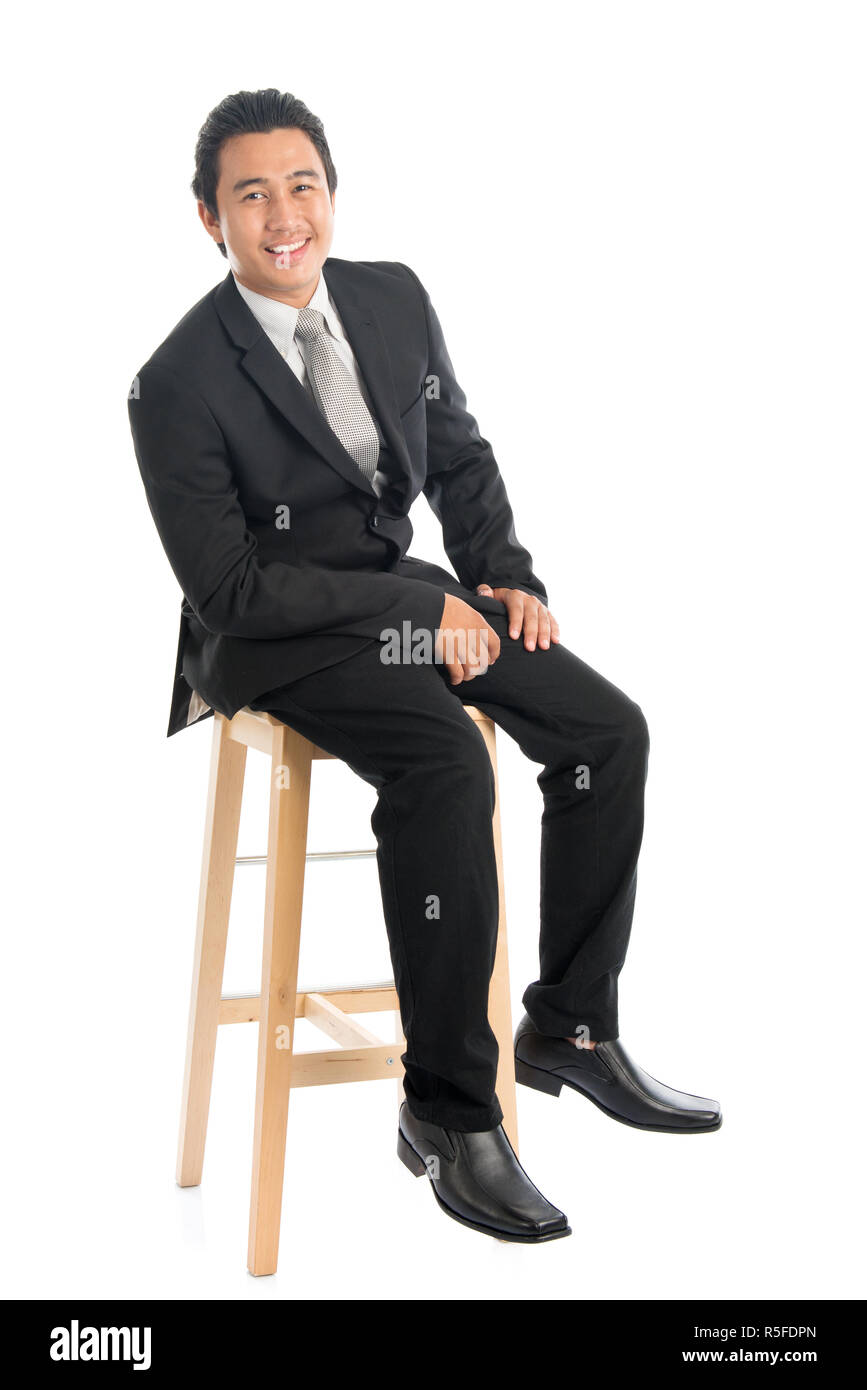 Corps complet Asian businessman assis sur la chaise haute Banque D'Images