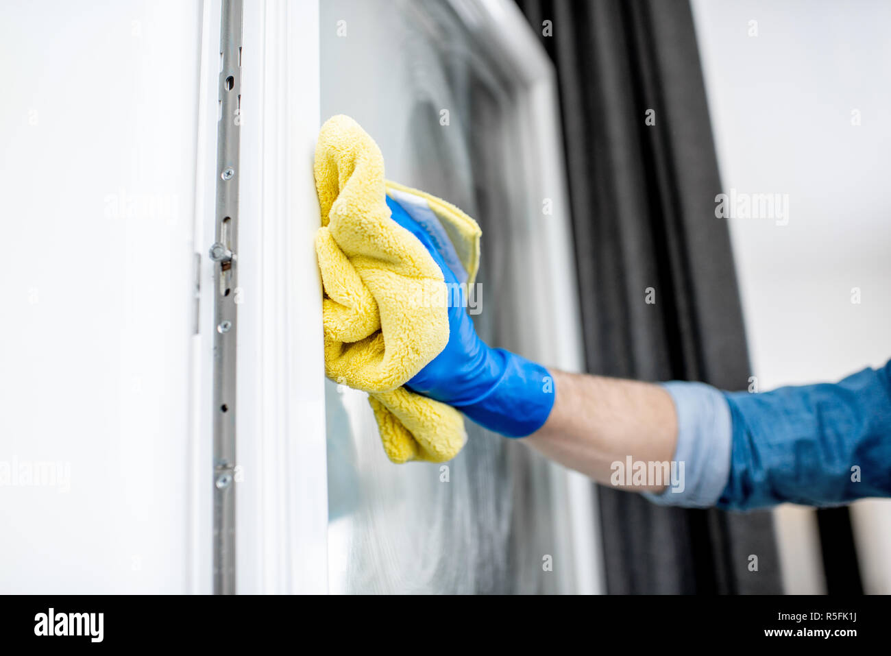 Close-up of a man in gant de protection lave-vitre avec de l'essuie-glace en coton jaune Banque D'Images