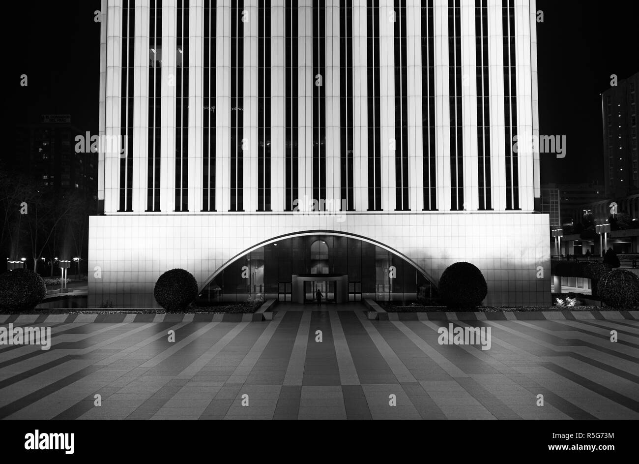 Une personne marche méconnaissable dans la Torre Picasso building at night, dans le quartier d'AZCA à Madrid, Espagne. Noir et blanc. Banque D'Images