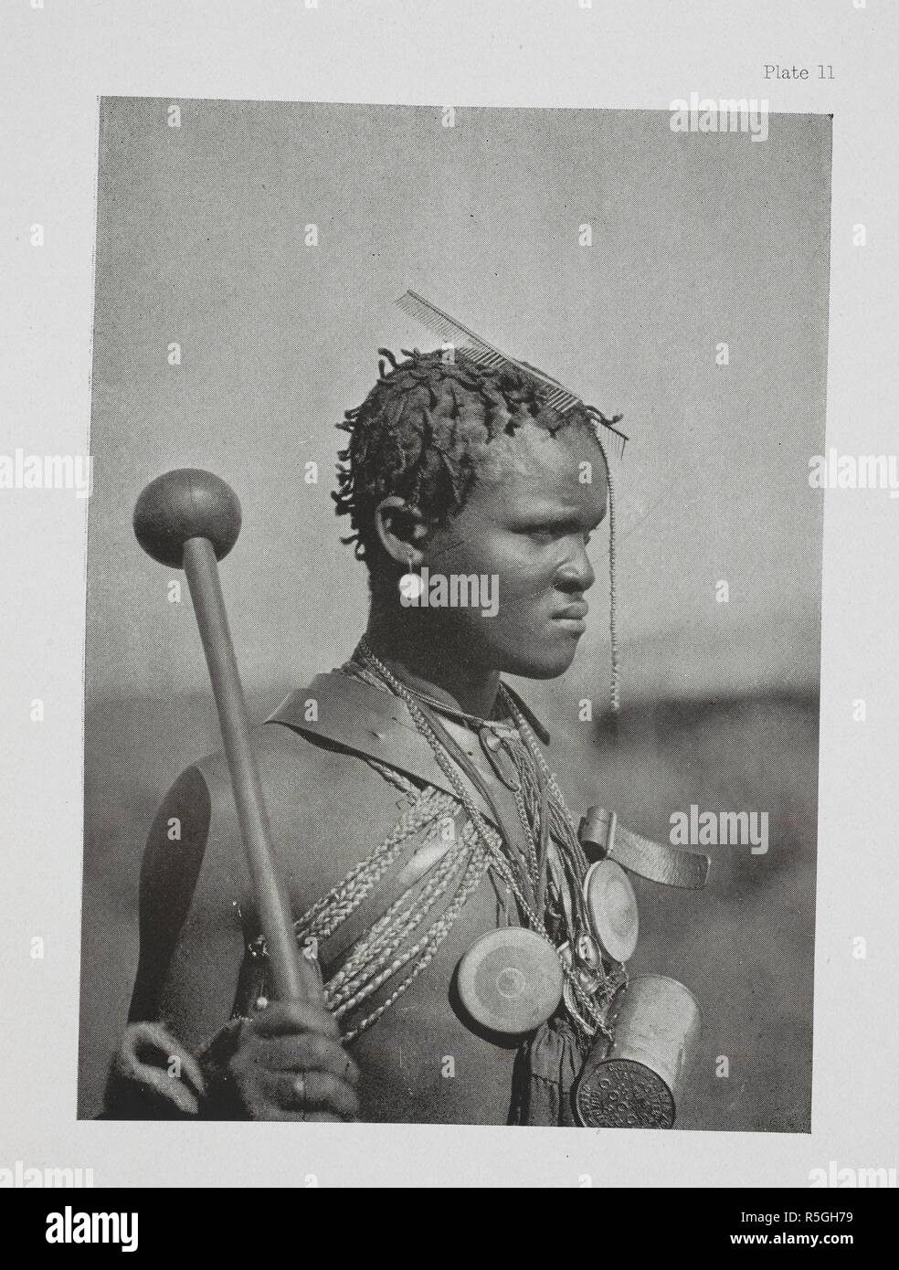 Un dandy Pondo. Ce jeune homme a un knobkerrie dans sa main, quelques peignes métalliques dans ses cheveux, et une cocia-tin hung autour du cou comme ornement, ainsi qu'à deux-verres en cas de tables rondes en bois. Il a formé quelques brins de cheveux de tomber en face de son nez, et a tendu quelques perles sur les cheveux pour l'ornement. Les Kafirs ... Avec une centaine d'illustrations pleine page par l'auteur. Londres : Adam & Charles Black, 1904. Source : 10096.h.20 Figure 11. Auteur : Kidd, Dudley. Banque D'Images