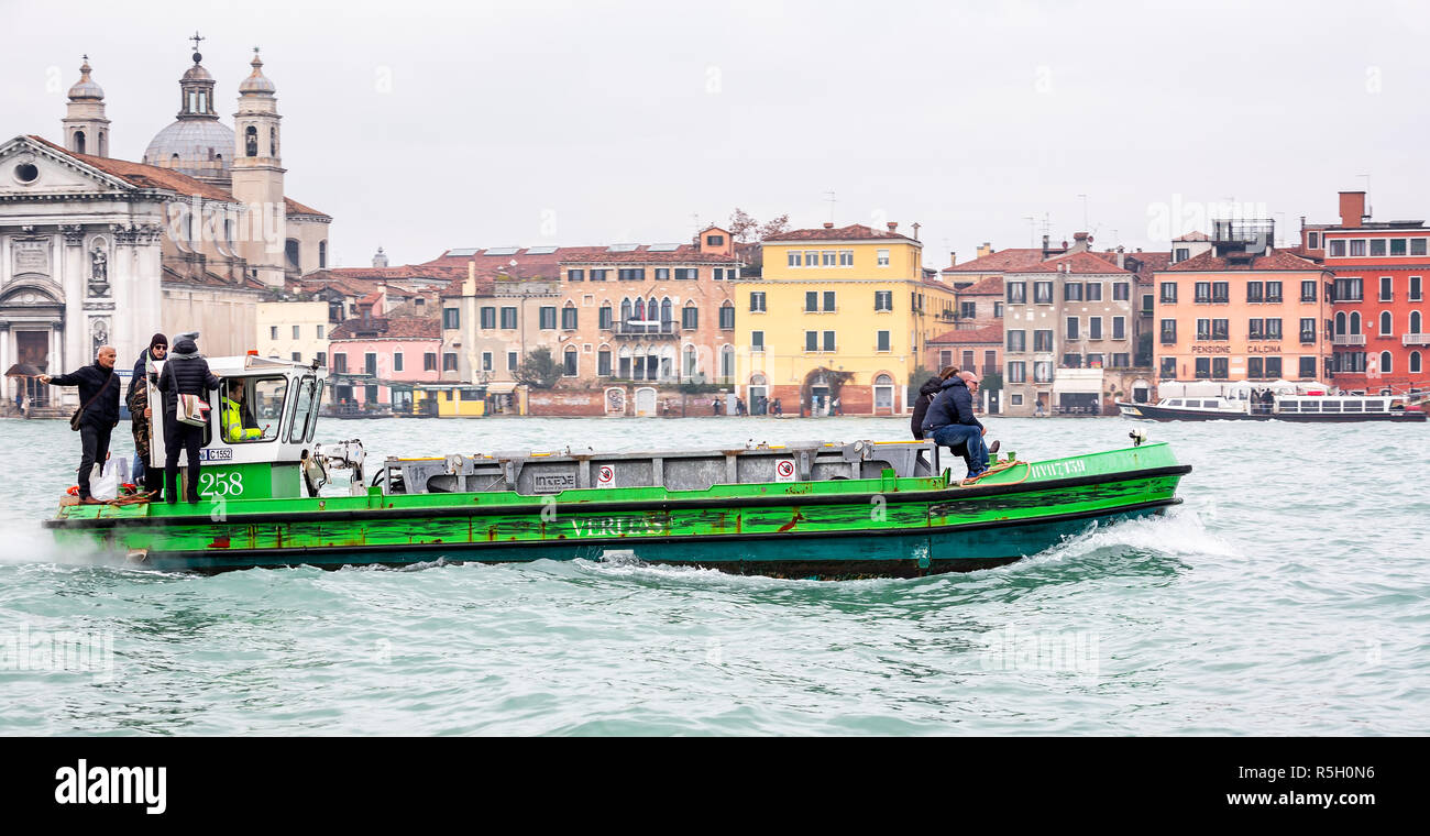 La collecte des ordures bateau sur le Grand Canal avec l'équilibre précaire de passagers à Venise, Italie, le 26 novembre 2018 Banque D'Images