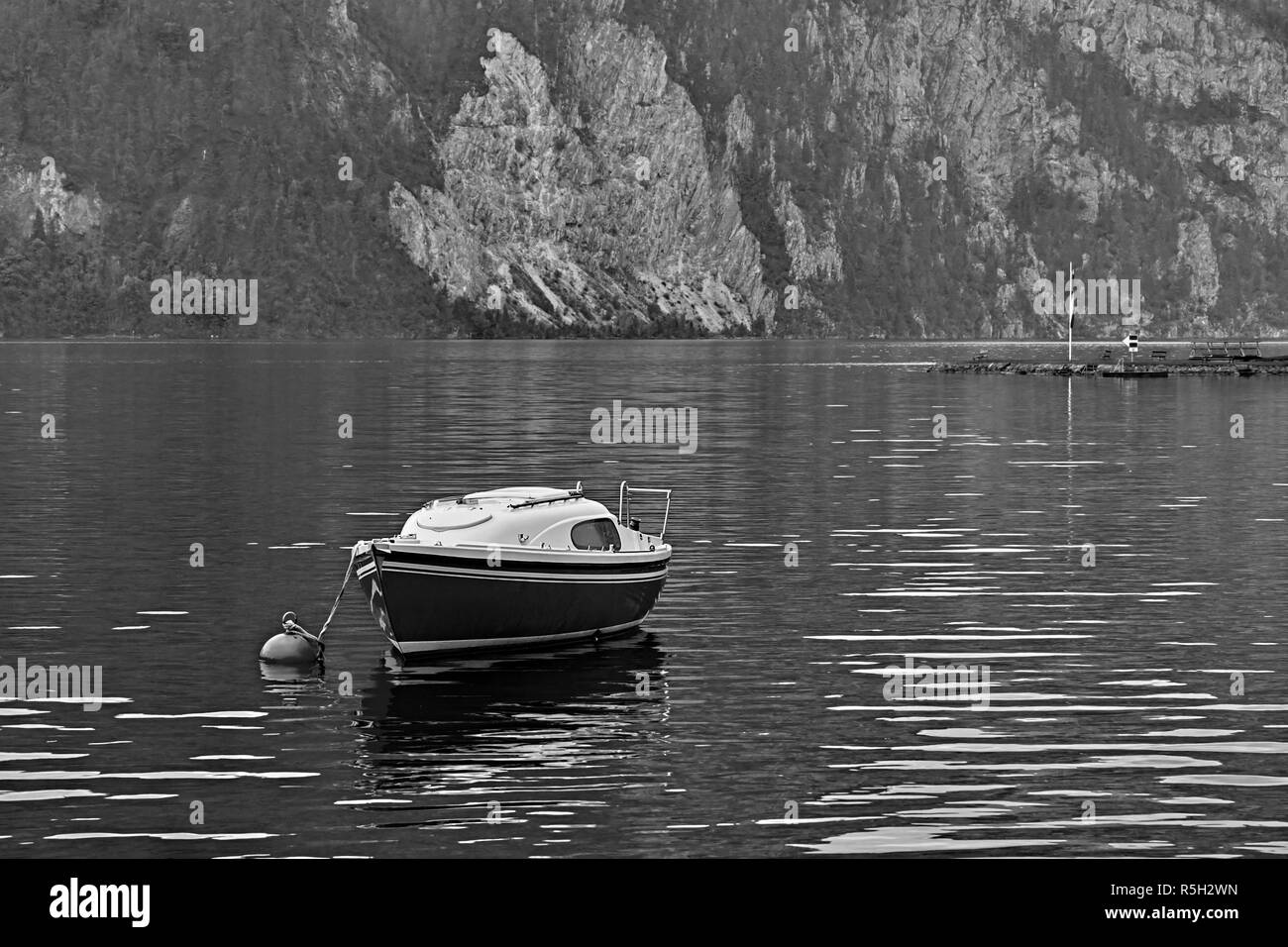 Vintage noir et blanc vue sur le calme et paisible lac Alpes autrichiennes. Bateau ou yacht solitaire au bord du lac près de Hallstatt Salzkammergut Autriche. Banque D'Images