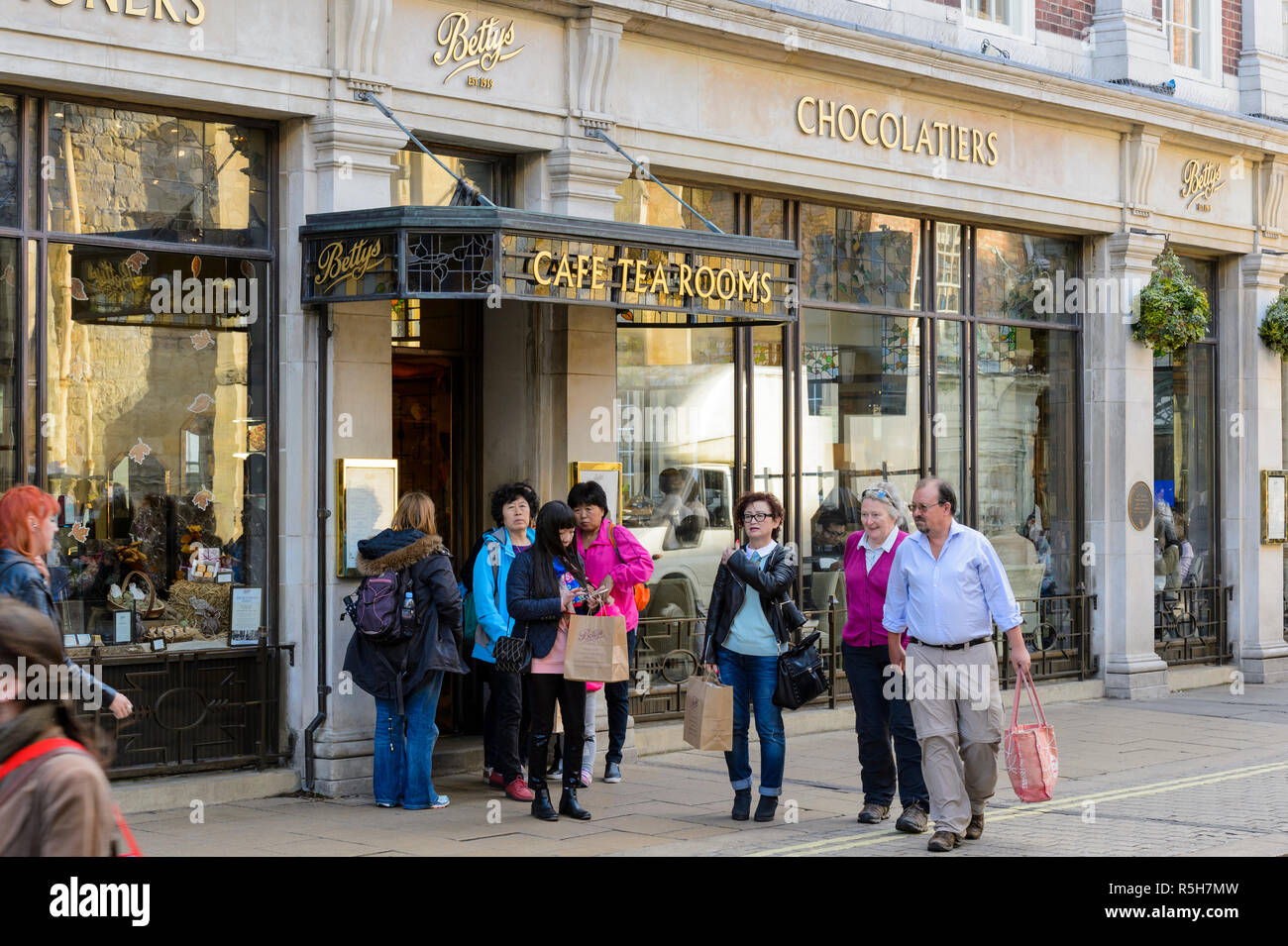 Betty's Cafe Tea Rooms exterior (populaires cafe & restaurant) avec les gens qui passent & clients debout près de l'entrée - York, North Yorkshire, Angleterre, Royaume-Uni. Banque D'Images Betty's Cafe Tea Rooms exterior (populaires cafe & restaurant) avec les gens qui passent & clients debout près de l'entrée - York, North Yorkshire, Angleterre, Royaume-Uni. Banque D'Images