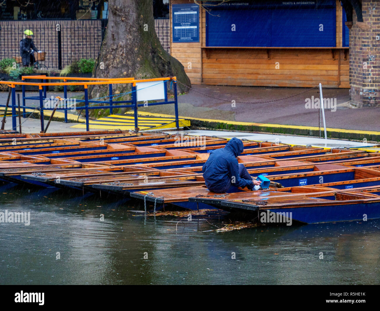 Le tourisme d'hiver Cambridge - un employé de l'eau se vide à partir de plates au centre-ville de Cambridge Banque D'Images