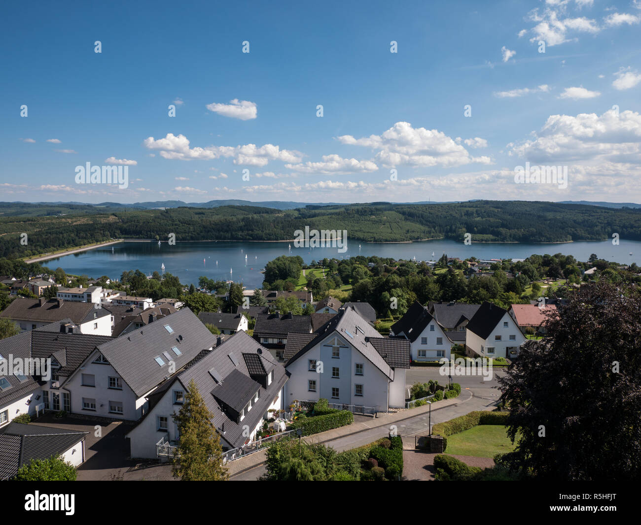 Vue panoramique sur le lac Sorpesee avec certains bateaux à voile et sone maisons de Langscheid à Sauerland, Allemagne dans l'avant Banque D'Images