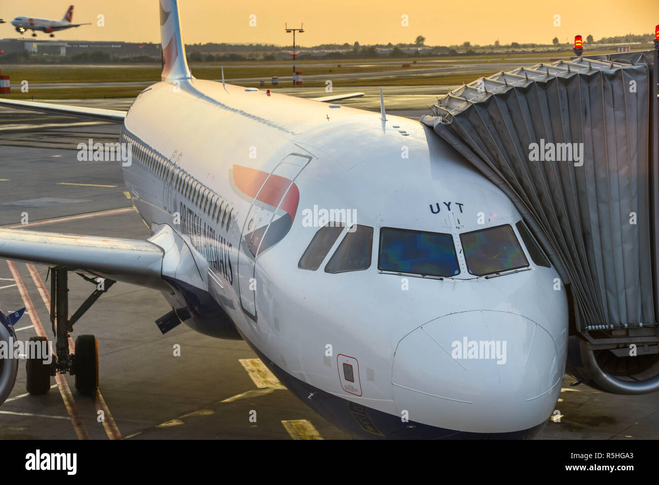 British Airways Airbus A320 jet relié à un pont aérien de passagers à l'aéroport de Prague prêt pour un départ tôt le matin Banque D'Images