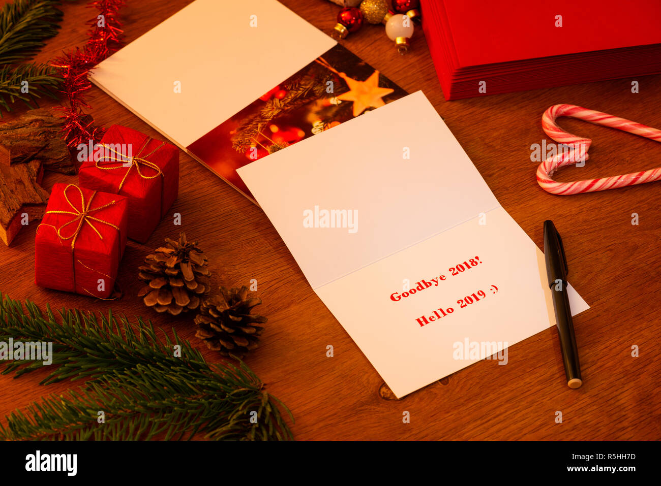 Au revoir 2018 Bonjour 2019 Carte de Noël et Nouvel An, en attente d'être signé avec un marqueur. Pile d'autres cartes et enveloppes à l'arrière-plan. Banque D'Images