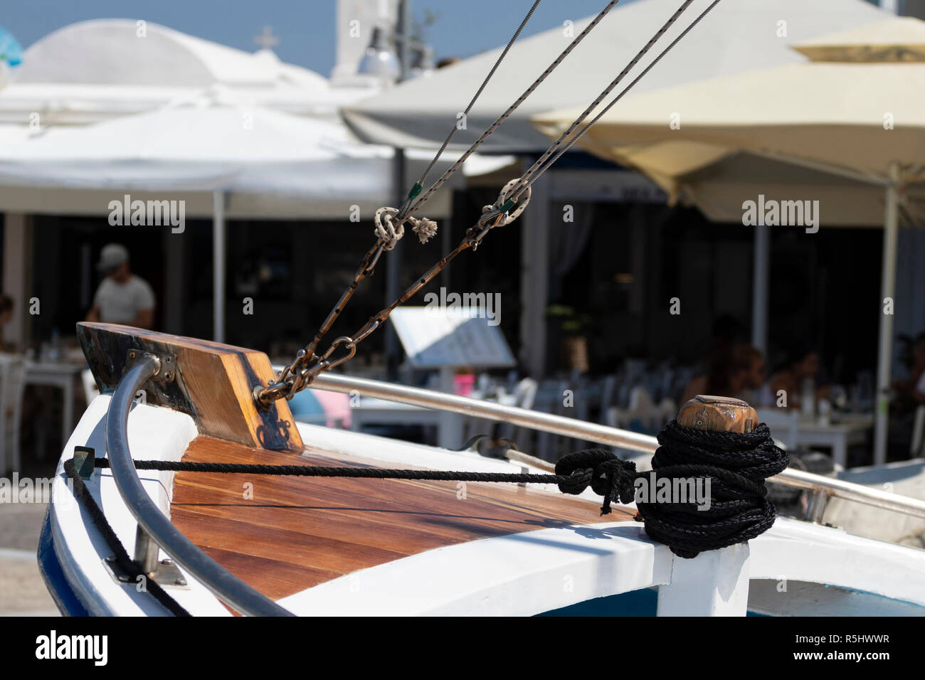 Pont d'un bateau à voile avec des lignes, restaurant de plage à l'arrière-plan, un jour ensoleillé dans l'île de Paros, Grèce, Banque D'Images