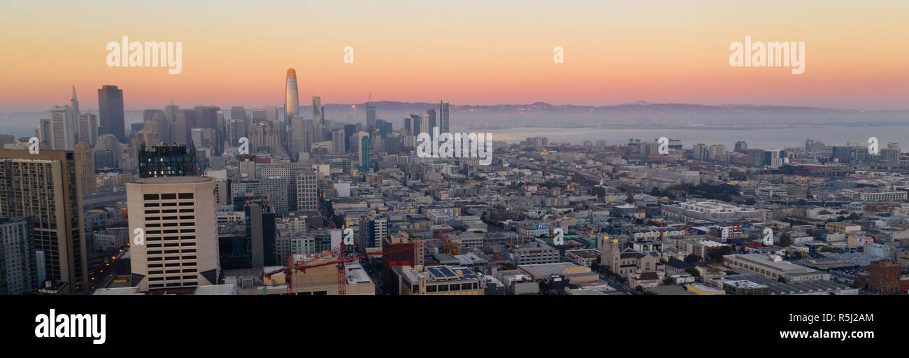 Teintes Orange semblent rebondir sur le bâtiment le plus haut que la nuit vient à la baie de San Francisco Banque D'Images