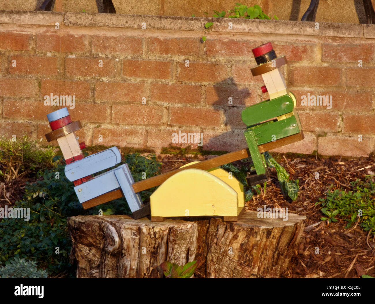 Jardin en bois Figurines Hommes nouveauté sur une balançoire, UK Banque D'Images