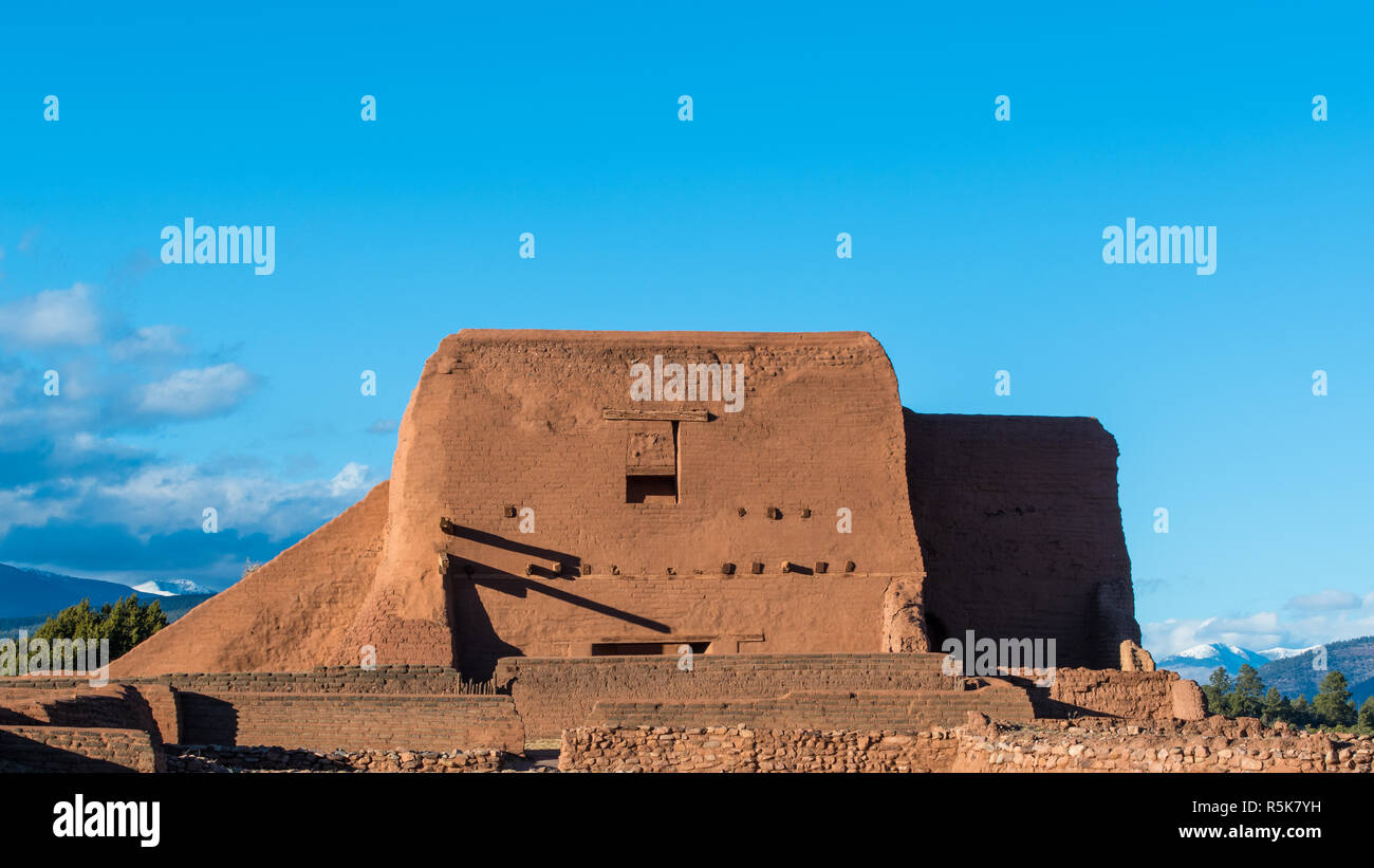 Ruines d'une ancienne église de la mission espagnole adobe avec des montagnes enneigées au loin à Pecos National Historical Park près de Santa Fe, Nouveau Mexique Banque D'Images