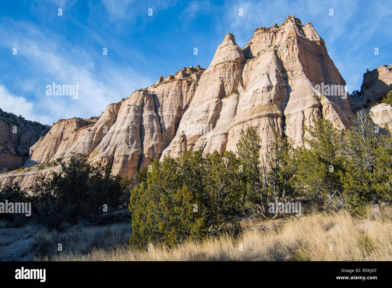 Formation rocheuse érodée, raide avec plusieurs pics acérés sous un ciel bleu avec des nuages vaporeux à Kasha-Katuwe Tent Rocks National Monument, Nouveau Mexique Banque D'Images