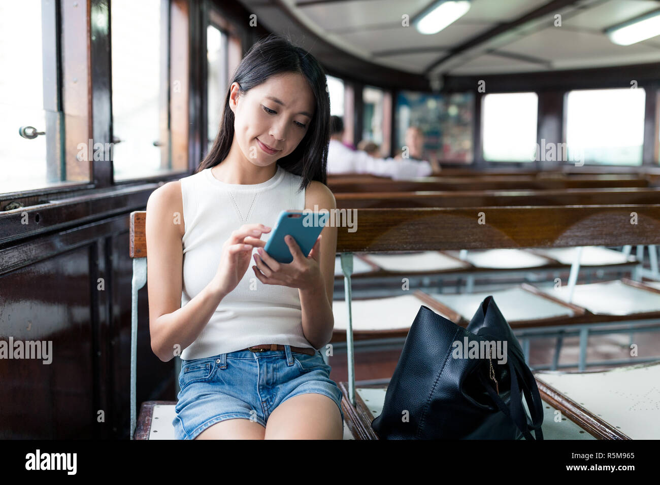 Femme à l'aide de smart phone et ferry Banque D'Images