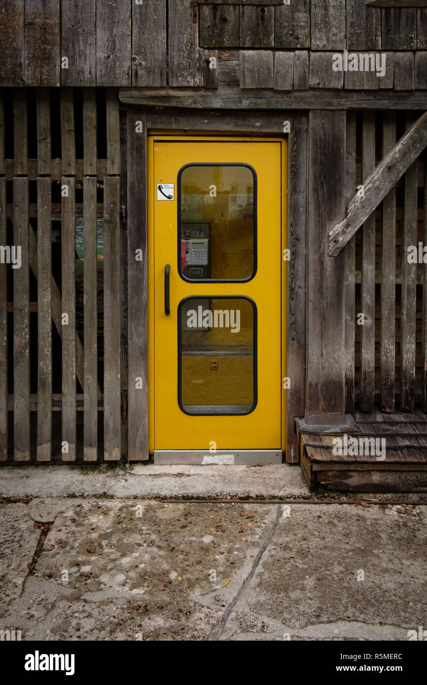 Une cabine téléphonique jaune à l'intérieur d'une grange Banque D'Images