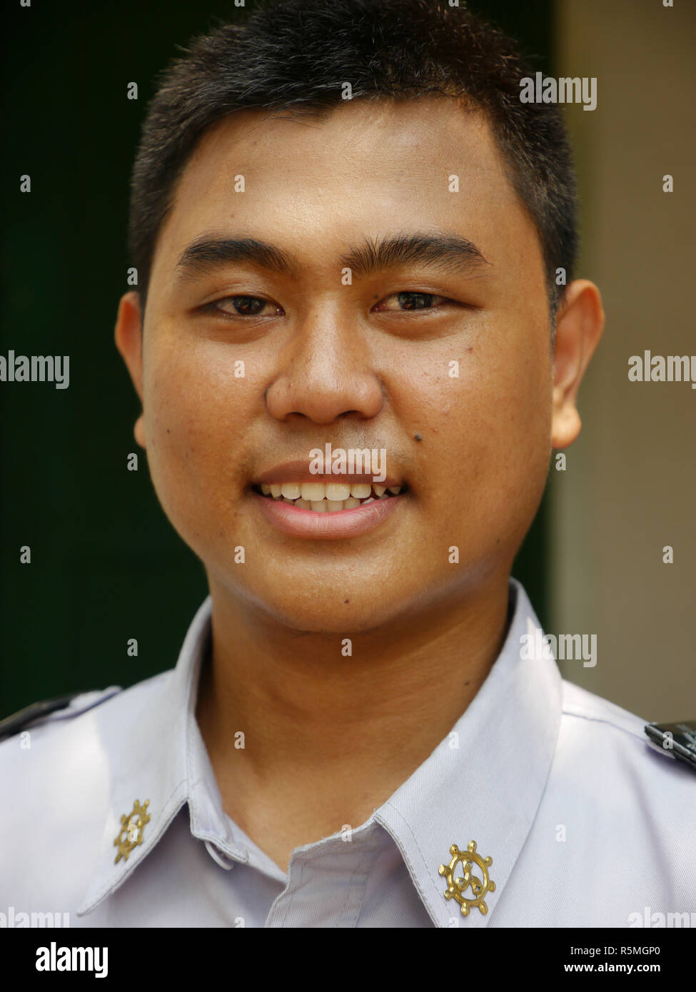 Portrait vertical de jeunes cadets de la marine indonésienne souriant en uniforme à directement à l'appareil photo. Banque D'Images